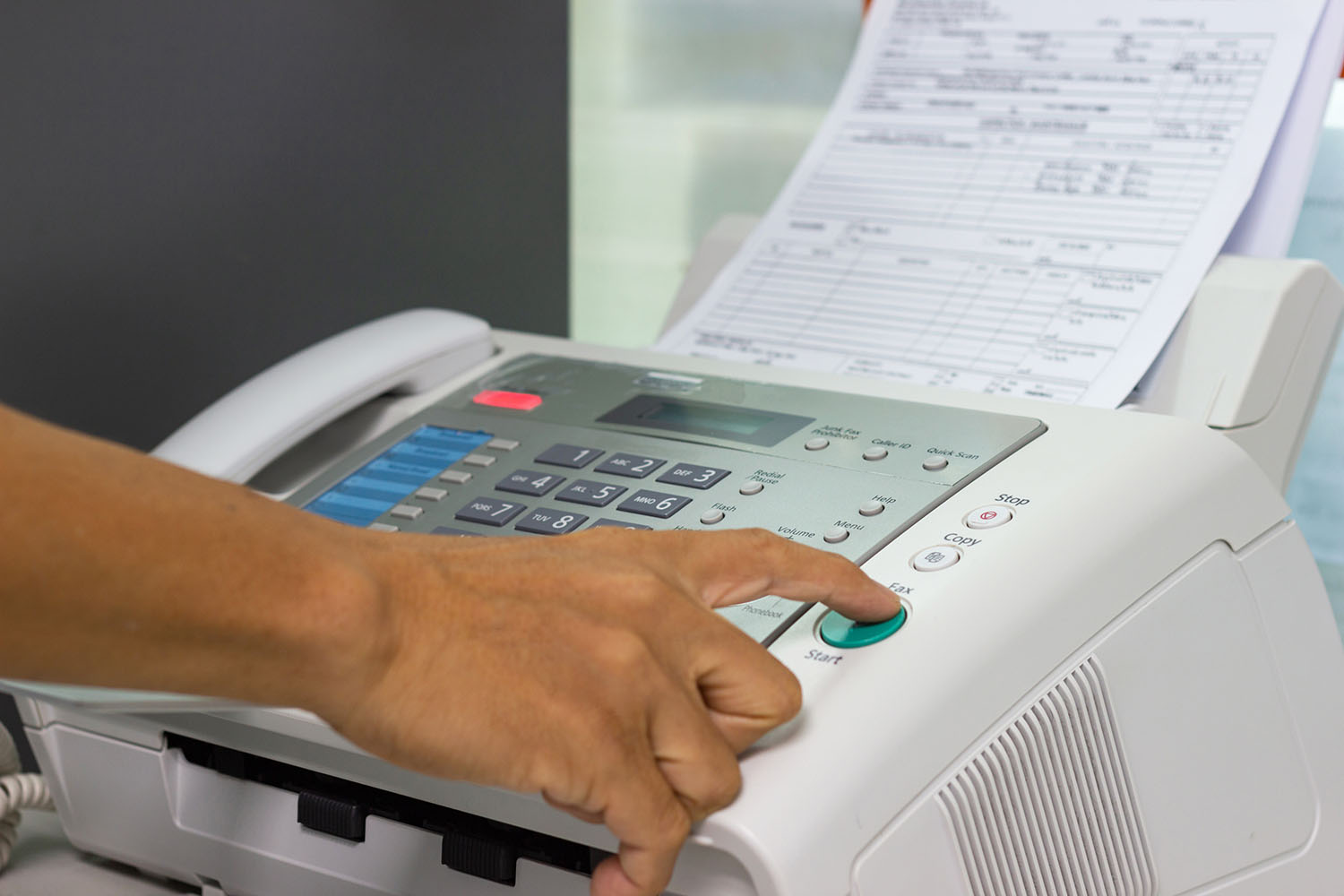 Hand man are using a fax machine in the office. Business concept